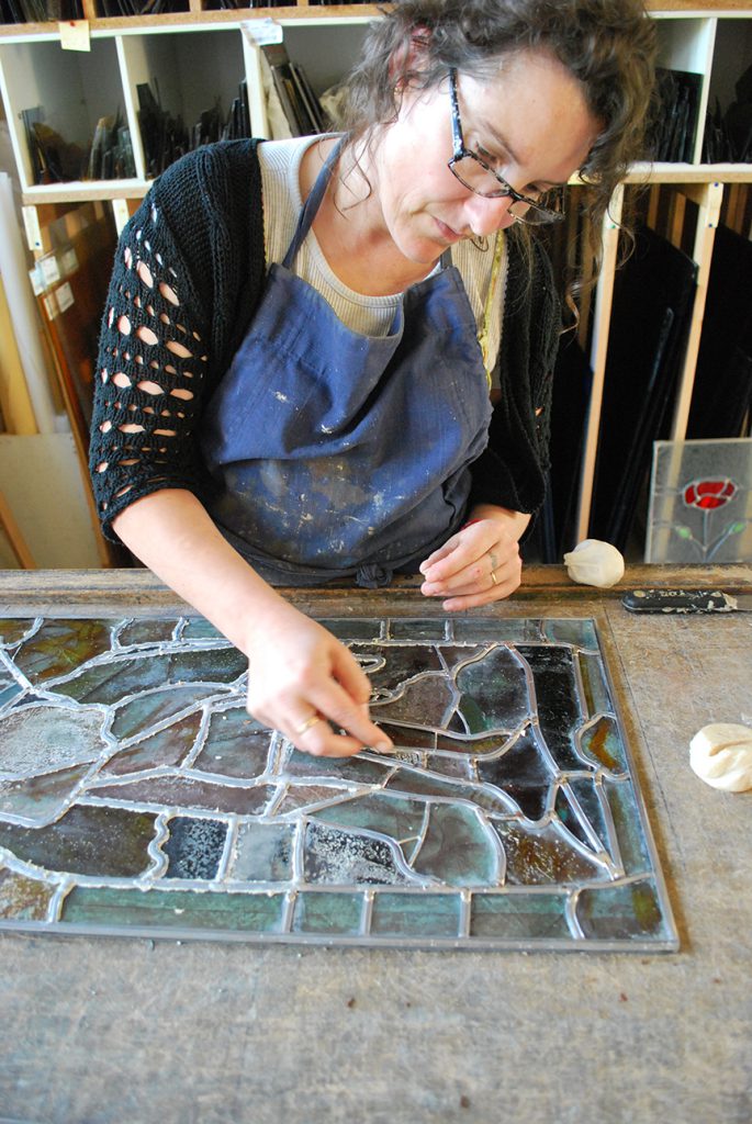 Françoise Théallier en train de créer un vitrail dans l'atelier 