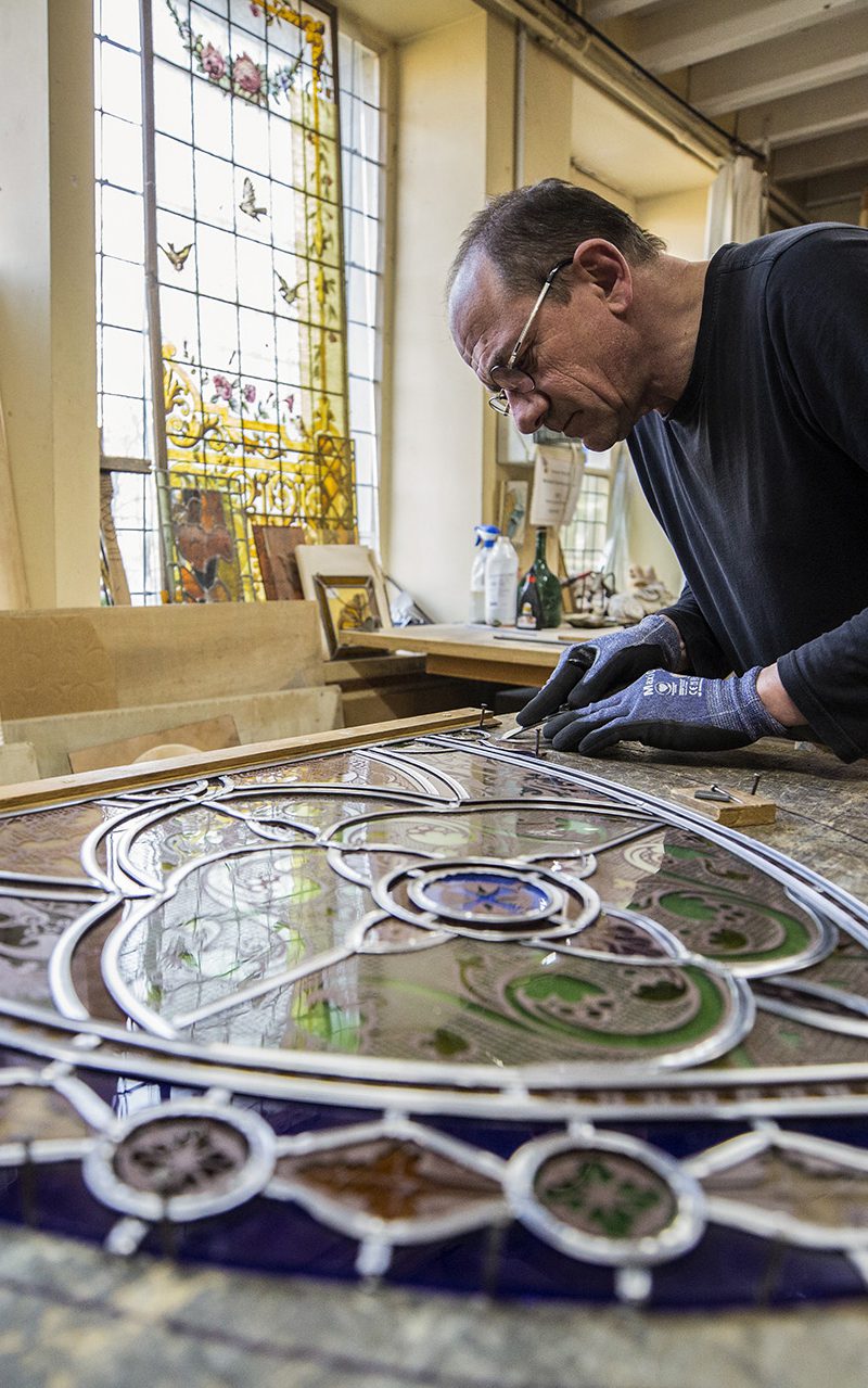 Philippe Riffaud en train de créer un vitrail dans l'atelier 