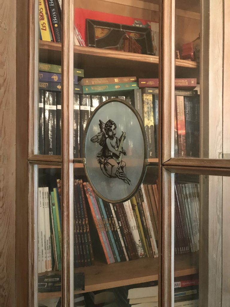 vitrail au motif romantique de chérubin posé sur une porte vitrée de bibliothèque chez un particulier, réalisé par l'Atelier Vitrail Saint-Joseph