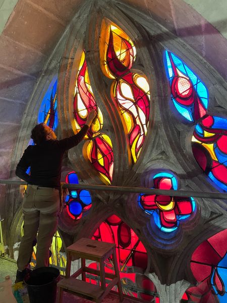 Françoise Théallier en train réaliser la pose d'un vitrail dans une église