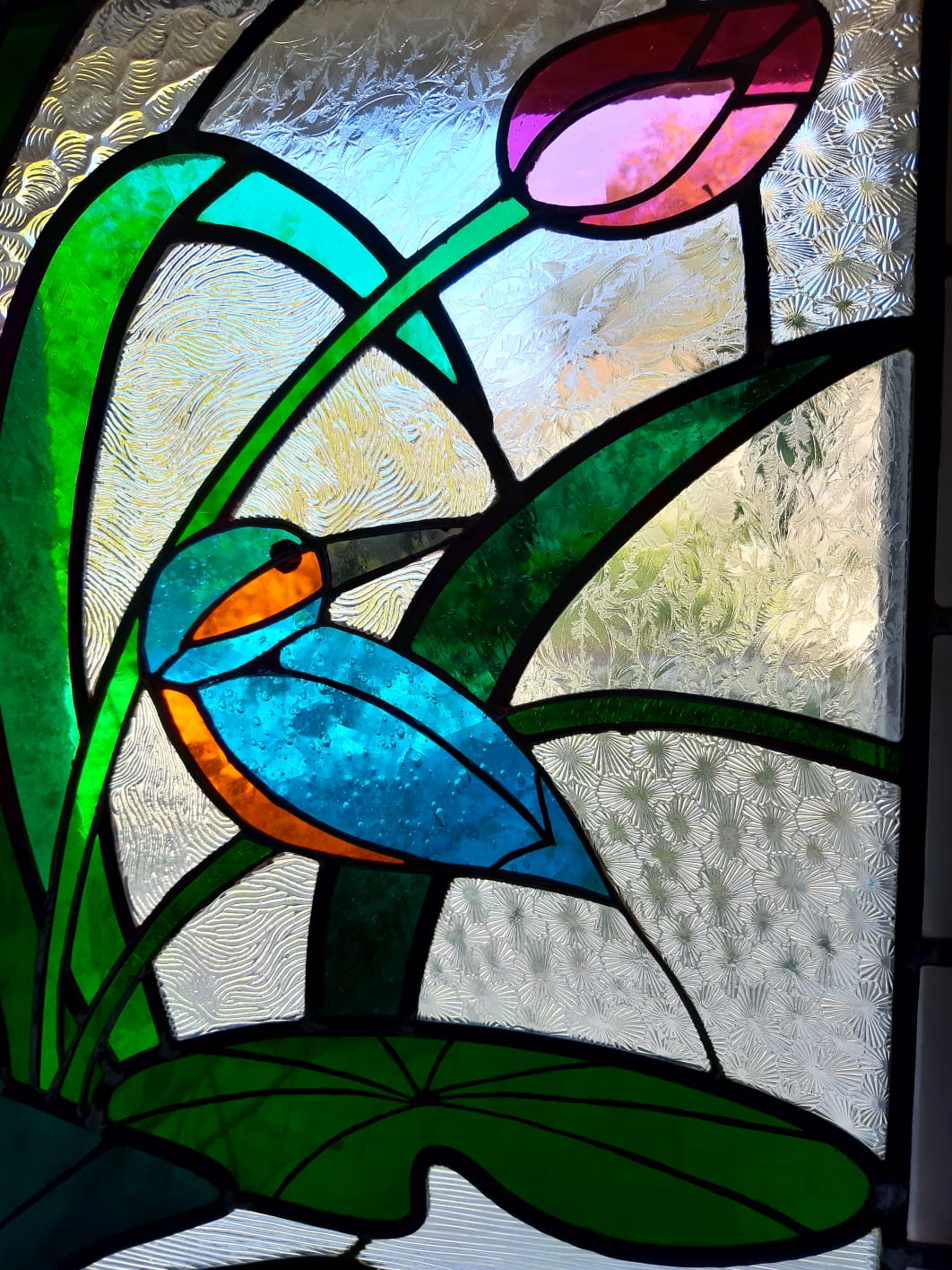 détail de vitrail : un oiseau et une tulipe