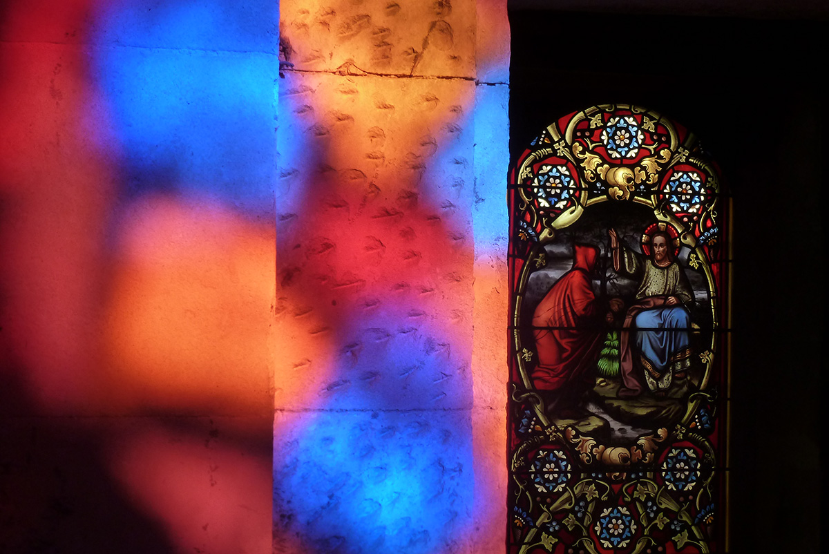 vitrail d'église et ses reflets colorés sur les murs