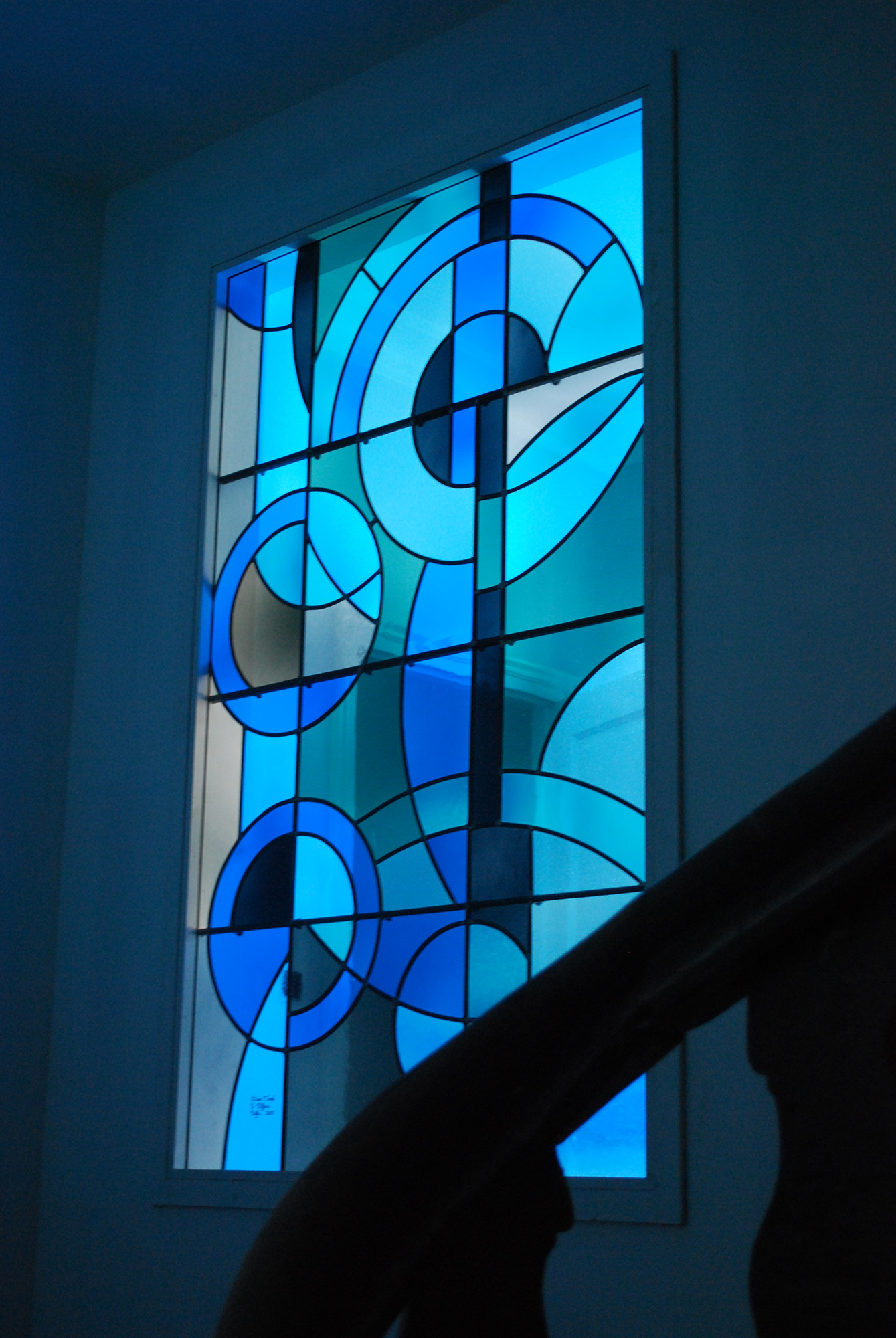 vitrail aux motifs géométriques posé sur une porte intérieure en décor de maison chez un particulier, réalisé par l'Atelier Vitrail Saint-Joseph